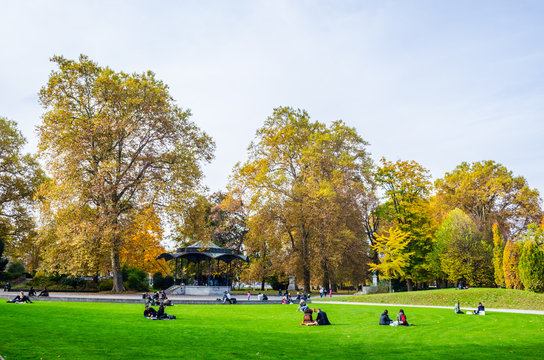 People are relaxing on a lawn in the platzspitz park in central zurich