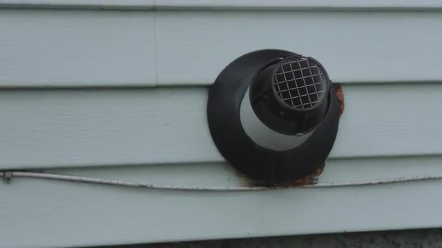 camera moves back and forward on a tankless water heater vent coming out of the side of a home