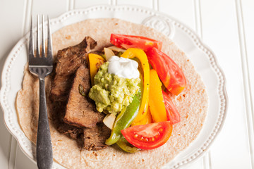 Fresh homemade steak fajitas on a white corrugated background