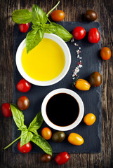 Fresh tomatoes, basil, olive oil and balsamic vinegar on wooden