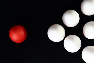 white eggs and red egg on a black background