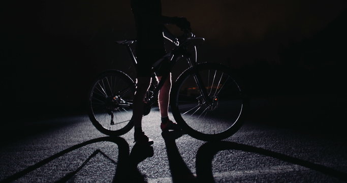 Low angle slow motion silhouette shot of cyclist posing