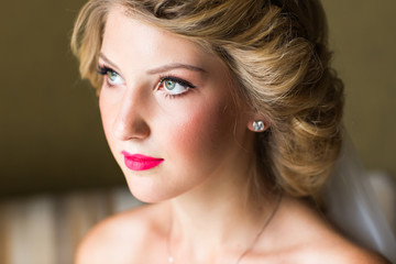 portrait of happy young woman in white wedding dress and bridal veil with flowers.