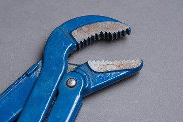 Blue adjustable spanner on grey