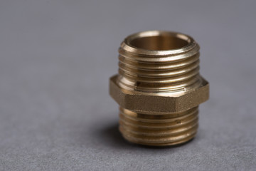 Brass plumbing nipple on grey table