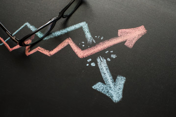 Two graphs are drawn on the blackboard with chalk. One breaks through the other. Business idea. Lots of space for text