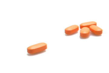 Orange pills on white background