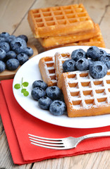 Belgian waffles with blueberries sprinkled with powdered sugar.