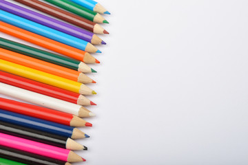 Close up picture of many little colored pencil crayons on white