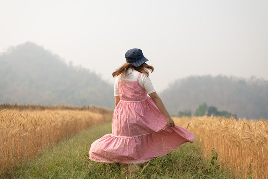 Girl is traveling into Barley field