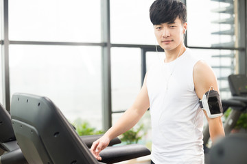 young handsome asian man works out in modern gynm