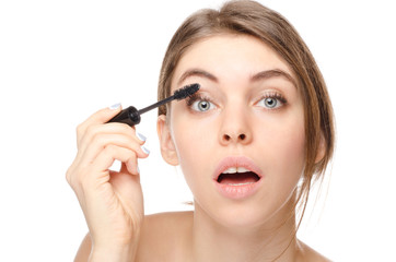 Beautiful woman applying mascara on her eyelashes - isolated on white