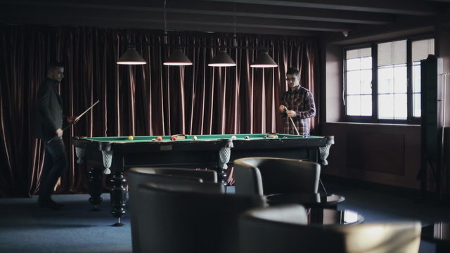 Friends are playing pool billiards