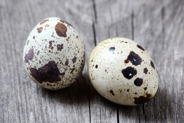 Obraz premium Two quail eggs on wooden table, close-up