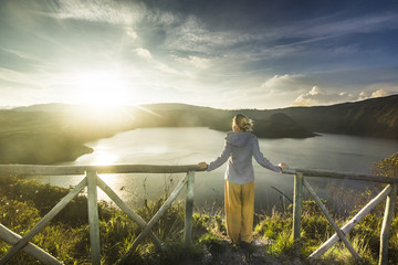 girl standing on a edge of crater with lake inside © sergeyonas