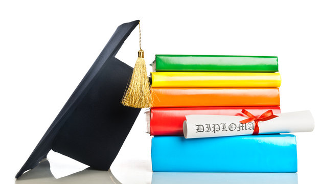 A mortarboard and graduation scroll, tied with red ribbon, on a