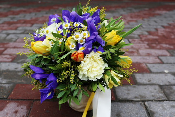 Beautiful bouquet of flowers: iris, mimosa, tulip, matricaria, rose, lisianthus