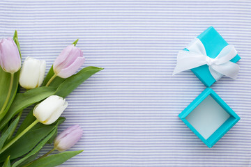 White and Lilac Tulips and Carton Gift Box on Striped Textile Background