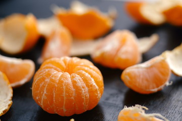 Cantels of mandarins with peels on a dark table. Macro