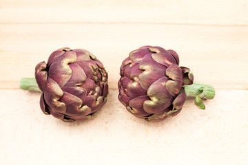 Obraz premium Artichokes with wooden kitchen board