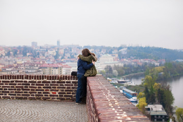 Fototapeta na wymiar young couple embracing on a viewing platform in Prague