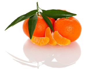 Fresh unpeeled orange mandarin citrus with green leafs and half