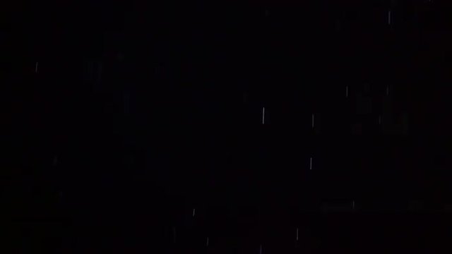 Slow motion of pouring rain and bright lightning flash in darkness. Thunderstorm at night