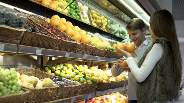 Young couple choosing fruits in store