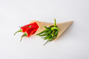 Red and green hot chili peppers in wafer cones - obrazy, fototapety, plakaty