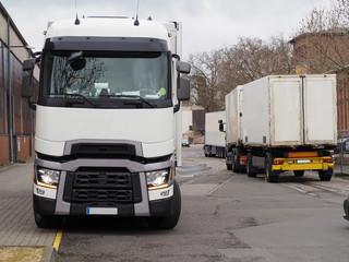 Mehrere LKW im Industriegelände vor einem Lagerhaus