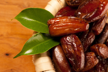 Sweet dried dates fruit in small bowl, mediterranean desert on w