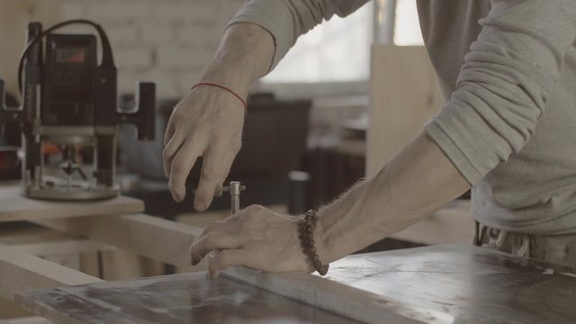 Woodworker fix metal balk on wooden board. Process of making furniture. Close up. Manufacturer. 