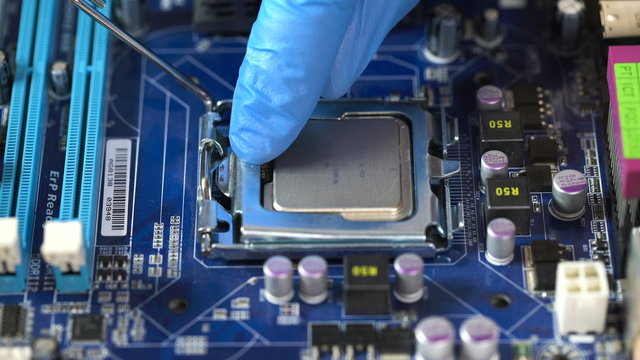 Technician plug in CPU microprocessor to motherboard socket. 