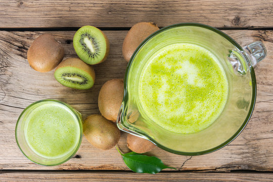 Fresh kiwi juice with mint on wooden background