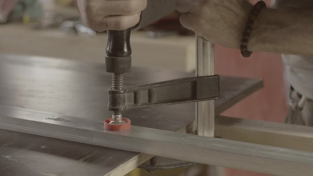 Professional carpenter fix metal balk on wooden board. Process making furniture. Manufacturer. 