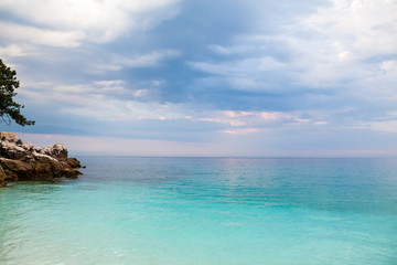 Obraz premium Saliara Beach (called Marble Beach), beautiful white beach in Thassos island, Greece. Landscape with water and rocks at sunset