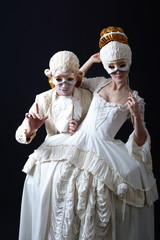 actor and actress in period costume holding a theatrical mask