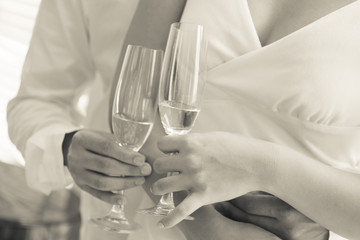 Bride and groom at the wedding table. holding a glass of champagne.