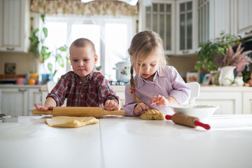 three children preparing cookies in the kitchen