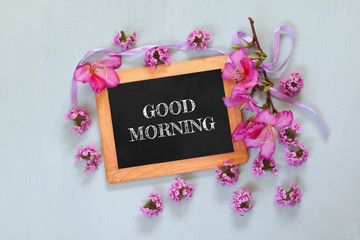 Fototapeta na wymiar blackboard with the phrase good morning written on it next to fresh flowers 