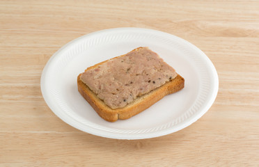 Fototapeta na wymiar Lemon pepper tuna on hard toast upon a wood table top