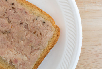 Lemon pepper tuna on hard toast upon a wood table top