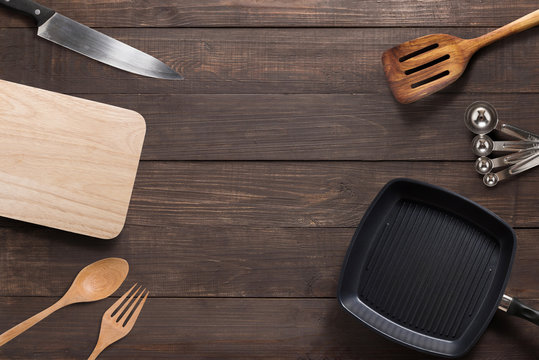 Various kitchenware utensils on the wooden background
