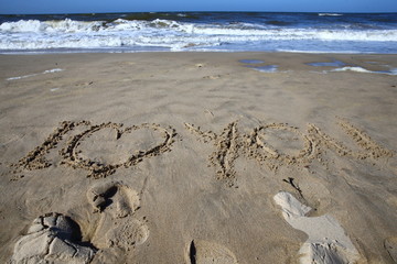 love/ words 'I love you' written in the sand while the waves wash them away