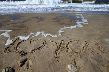 love/ words 'I love you' written in the sand while the waves wash them away