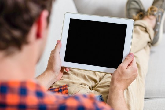 Handsome Man Using Tablet Computer On Couch