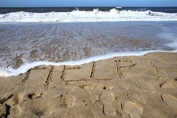 help/ words written in the sand on a beach 