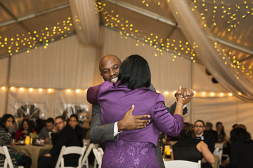 Black groom dancing with mother at reception