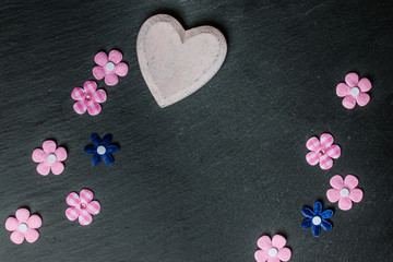Hintergrundgrafik, Holzherz und bunte Blümchen auf Schieferplatte