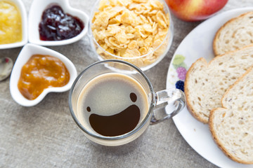 Colazione con caffè, cereali, marmellate, pane, toast, mela su tovaglia di lino